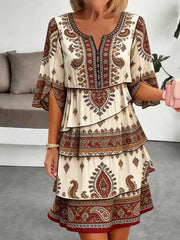 Boho tiered dress in cream with red paisley print, flutter sleeves, and V-neck.