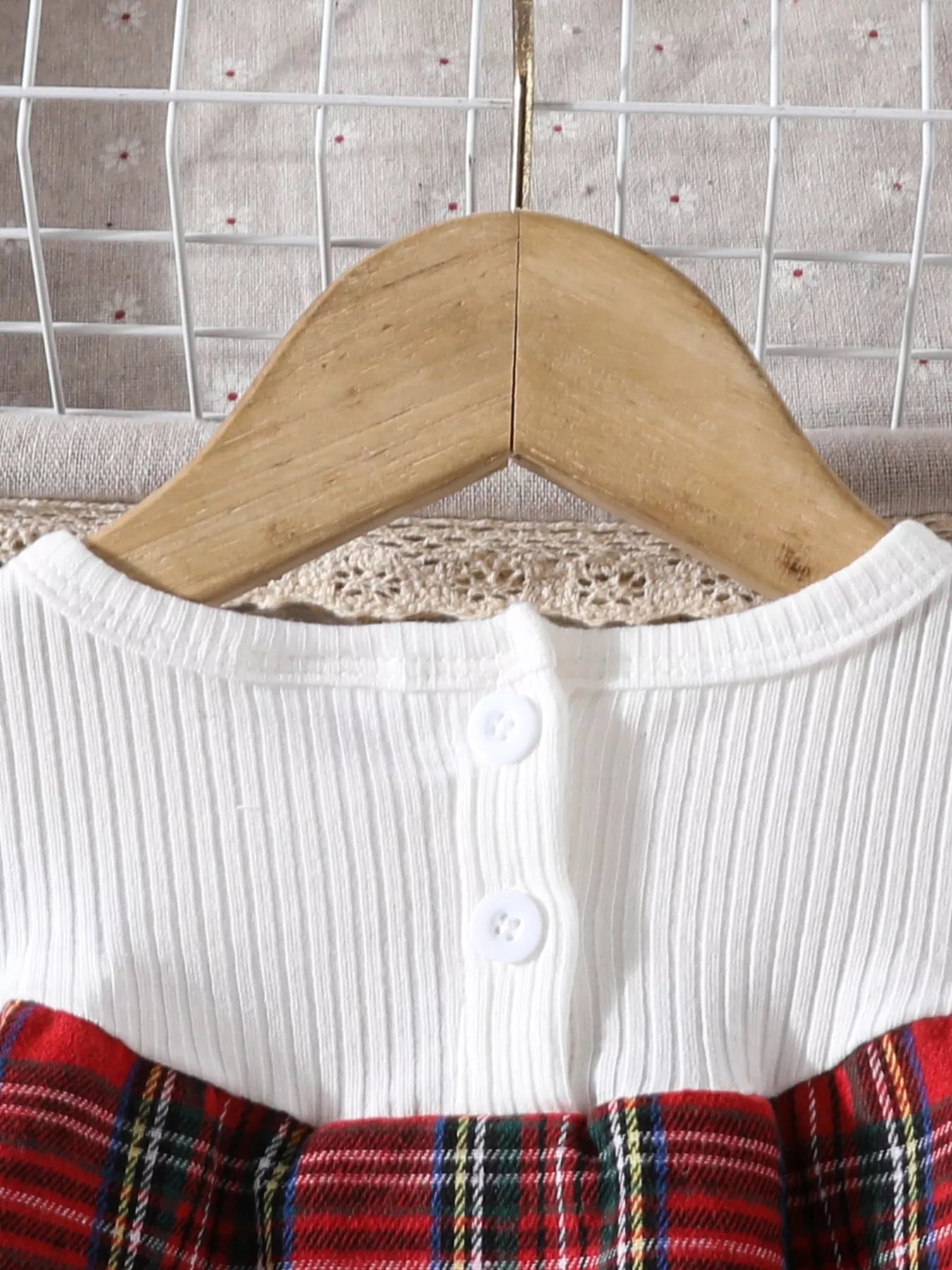 Baby girls' white ribbed top with burgundy plaid skirt and button detail.