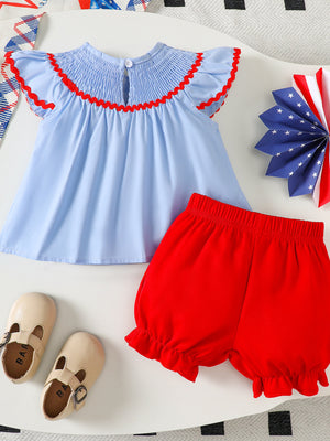 Baby smocked top with red trim and red bloomer shorts set.