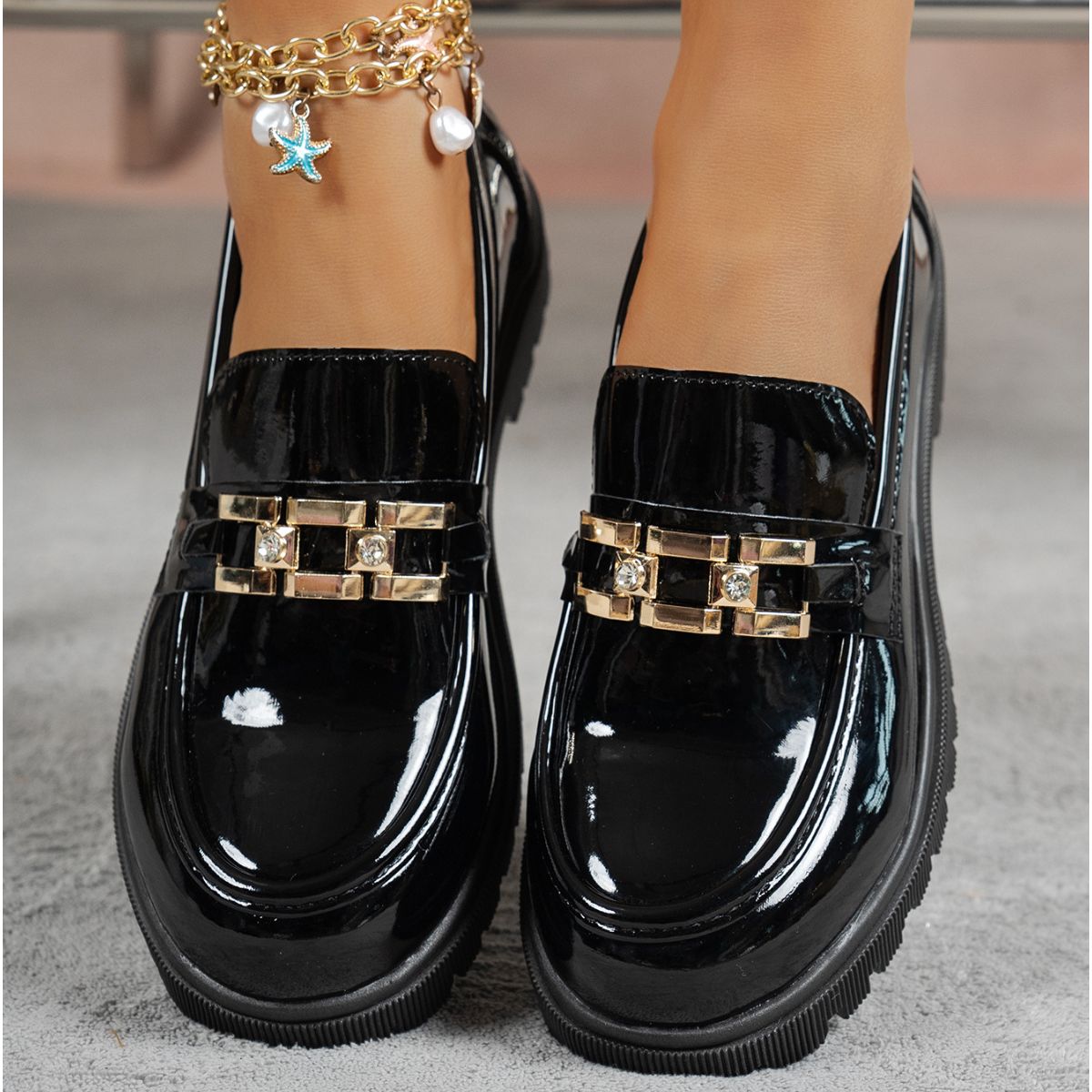 Black patent chunky loafers with gold buckle and crystal accents.