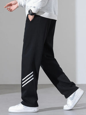 Black sweatpants with white stripes on the leg, loose fit, casual athleisure style.