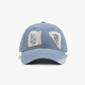 Distressed denim baseball cap in light blue with white patches and frayed details.