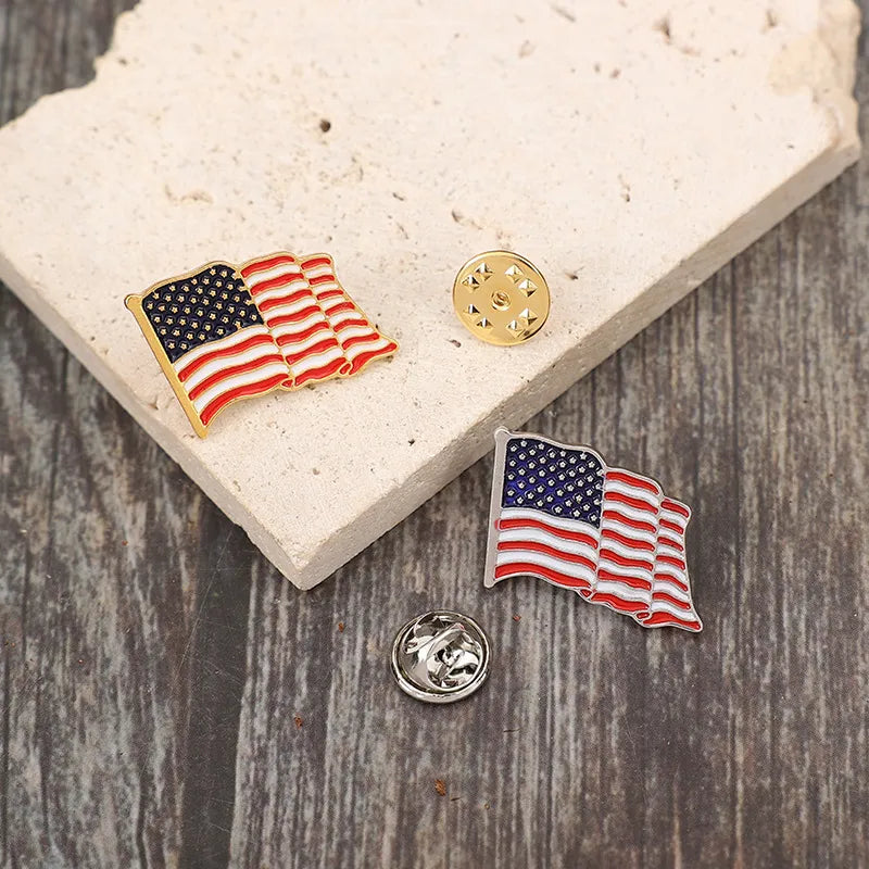 Waving flag enamel pins in red, white, and blue with gold and silver butterfly clutches.