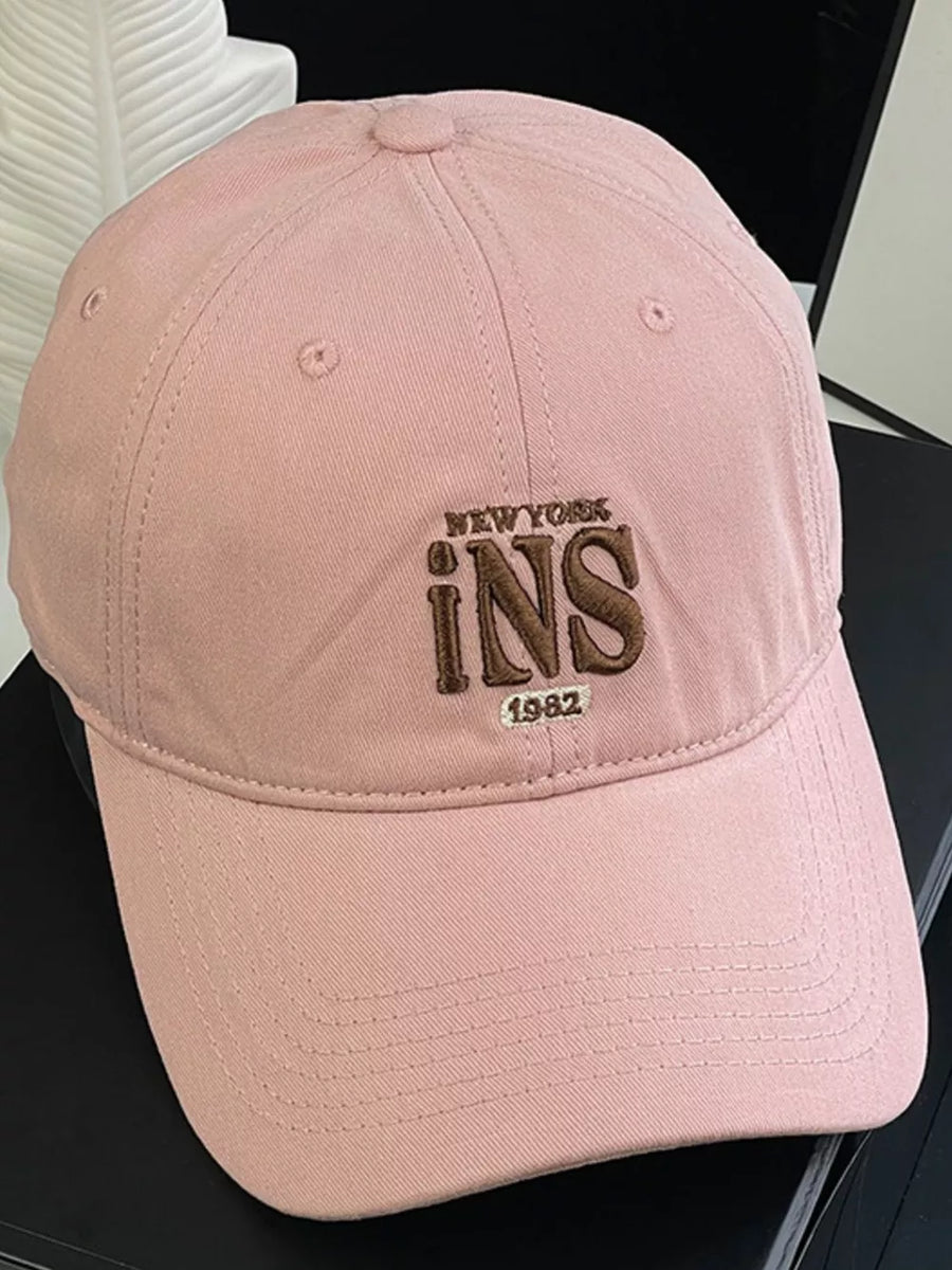 Pink baseball cap with embroidered New York INS 1982 detail