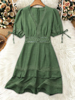 Green lace-embellished V-neck mini dress with tie sleeves and tiered skirt.