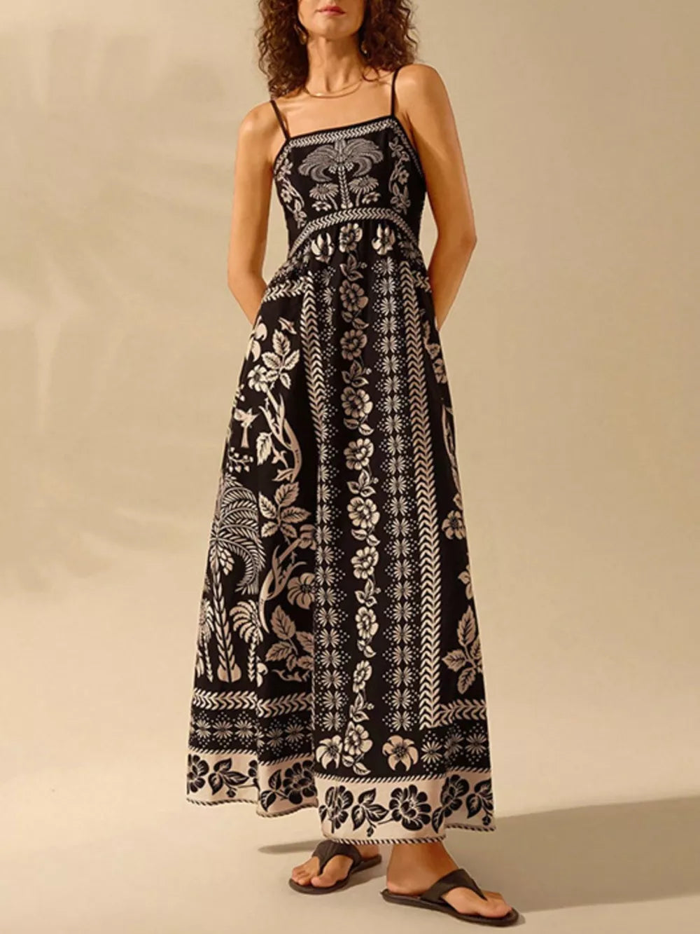 Black floral print spaghetti strap maxi dress with a-line cut and bohemian details.