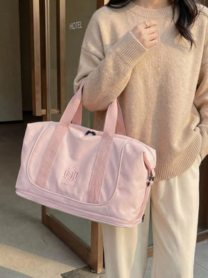 Pink duffel bag with embroidered logo and textured straps