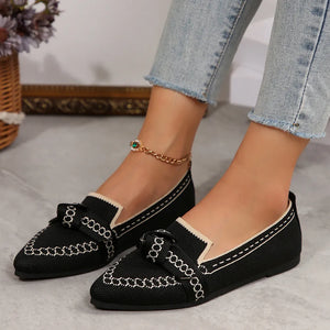 Black chain-stitched knit bow pointed flats with cream trim and white stitching.