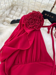 Red one-shoulder maxi dress with floral accent and ruffle details.