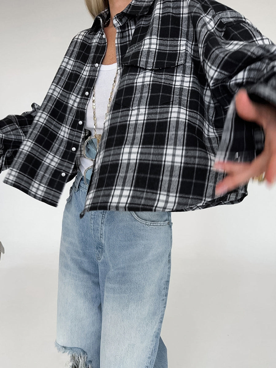 Oversized black and white plaid cotton button-up shirt with collar and chest pockets.
