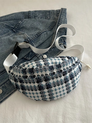 Textured houndstooth belt bag with adjustable white strap and black buckle.