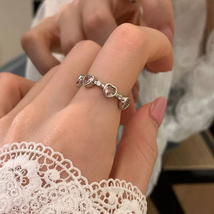 pink ring featuring heart-shaped zircons and heart motif