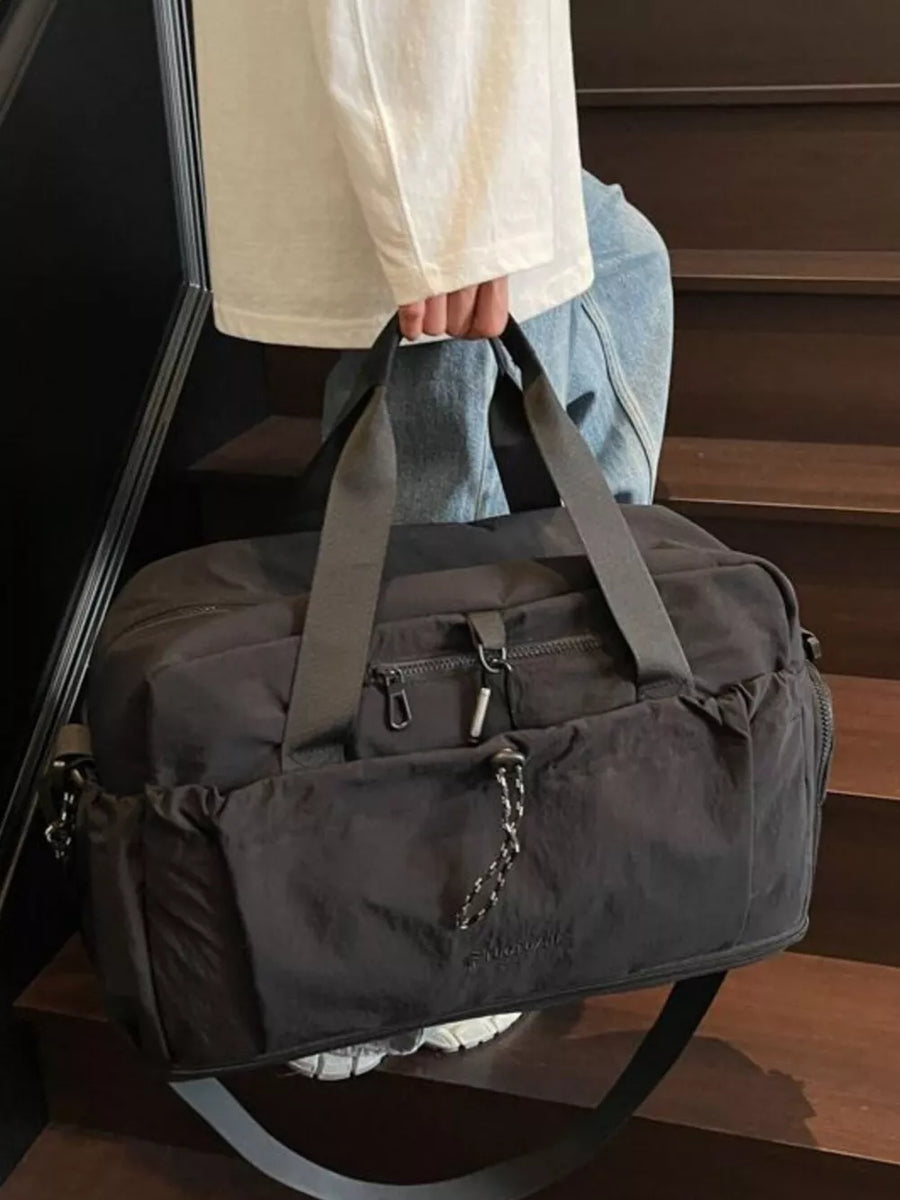 Black lightweight travel duffel bag with multiple zippered pockets and adjustable strap.