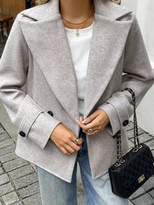 Wool blend double-breasted jacket in light grey with black buttons.