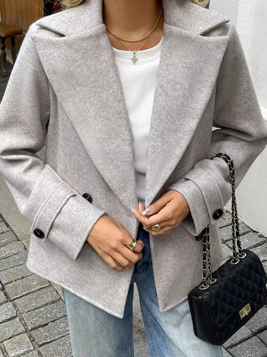 Wool blend double-breasted jacket in light grey with black buttons.