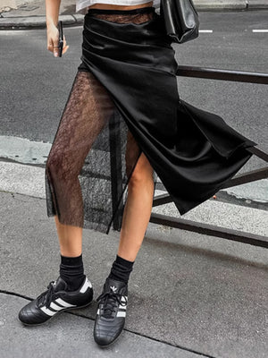 Black midi skirt with sheer lace panel and asymmetrical hem.