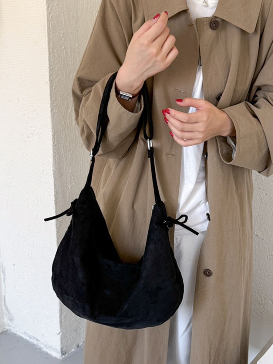 crossbody bag in black featuring adjustable straps and relaxed fit