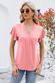 Coral V-neck top with pleated front and flutter sleeves.
