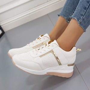 White lace-up wedge sneakers with metallic accents and perforated details.