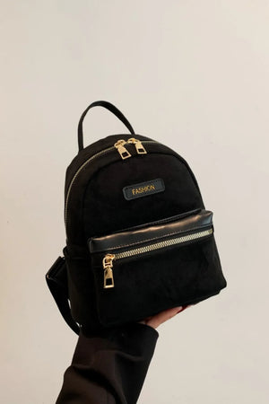 Black suede mini backpack with golden zips and "FASHION" detail