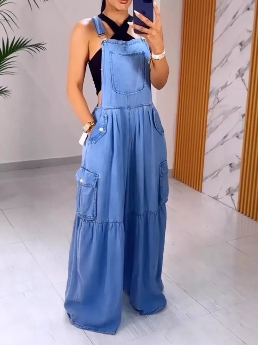 Blue denim wide-leg overalls with cargo pockets and tiered ruffle hem.