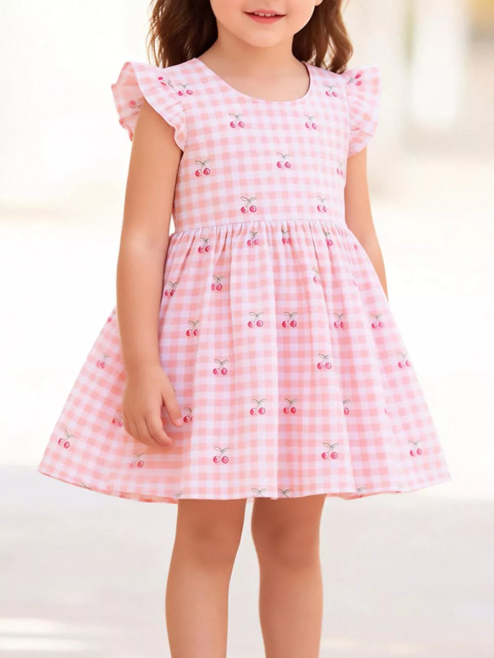 Pink gingham cotton dress with cherry embroidery and ruffle sleeves.