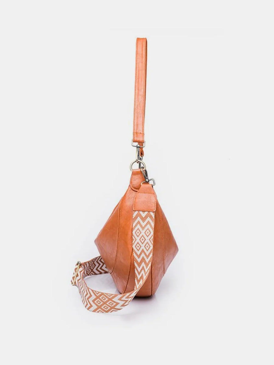 Terracotta leather crescent crossbody bag with geometric strap and wristlet strap