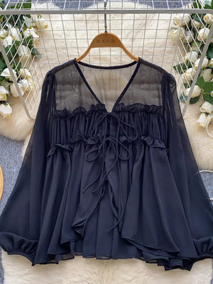 Black chiffon blouse with ruffled tie-front and sheer yoke.
