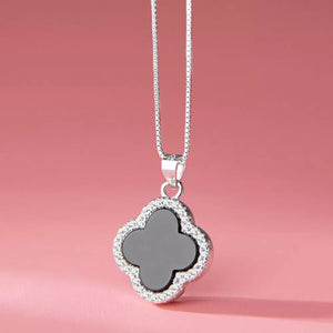 silver necklace featuring clover pendant and clover