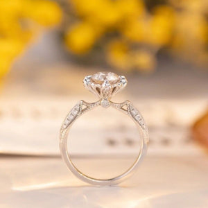 Sterling silver ring with moissanite center stone and diamond accents on band.