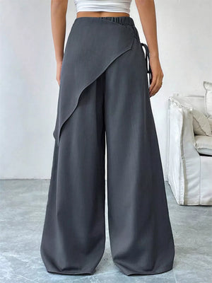 Gray wide-leg pants with a wrap-style overlay and tie detail
