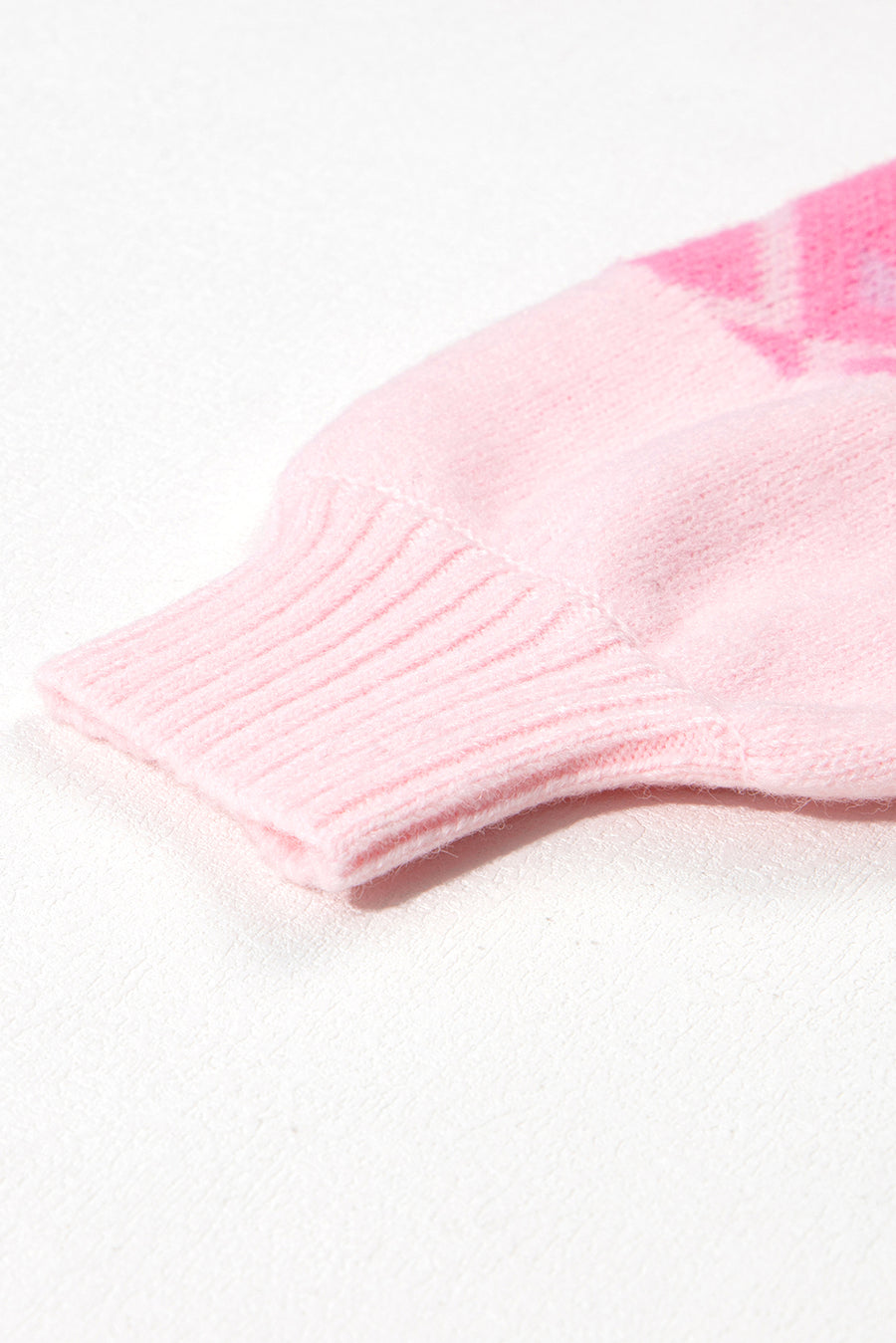Pink acrylic knit sweater with geometric pattern and ribbed cuff detail.