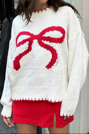 White knit crewneck sweater with a red graphic bow pattern and red scalloped trim.
