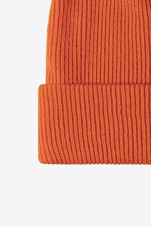 Ribbed knit beanie in tangerine, acrylic, with a cuffed hem.
