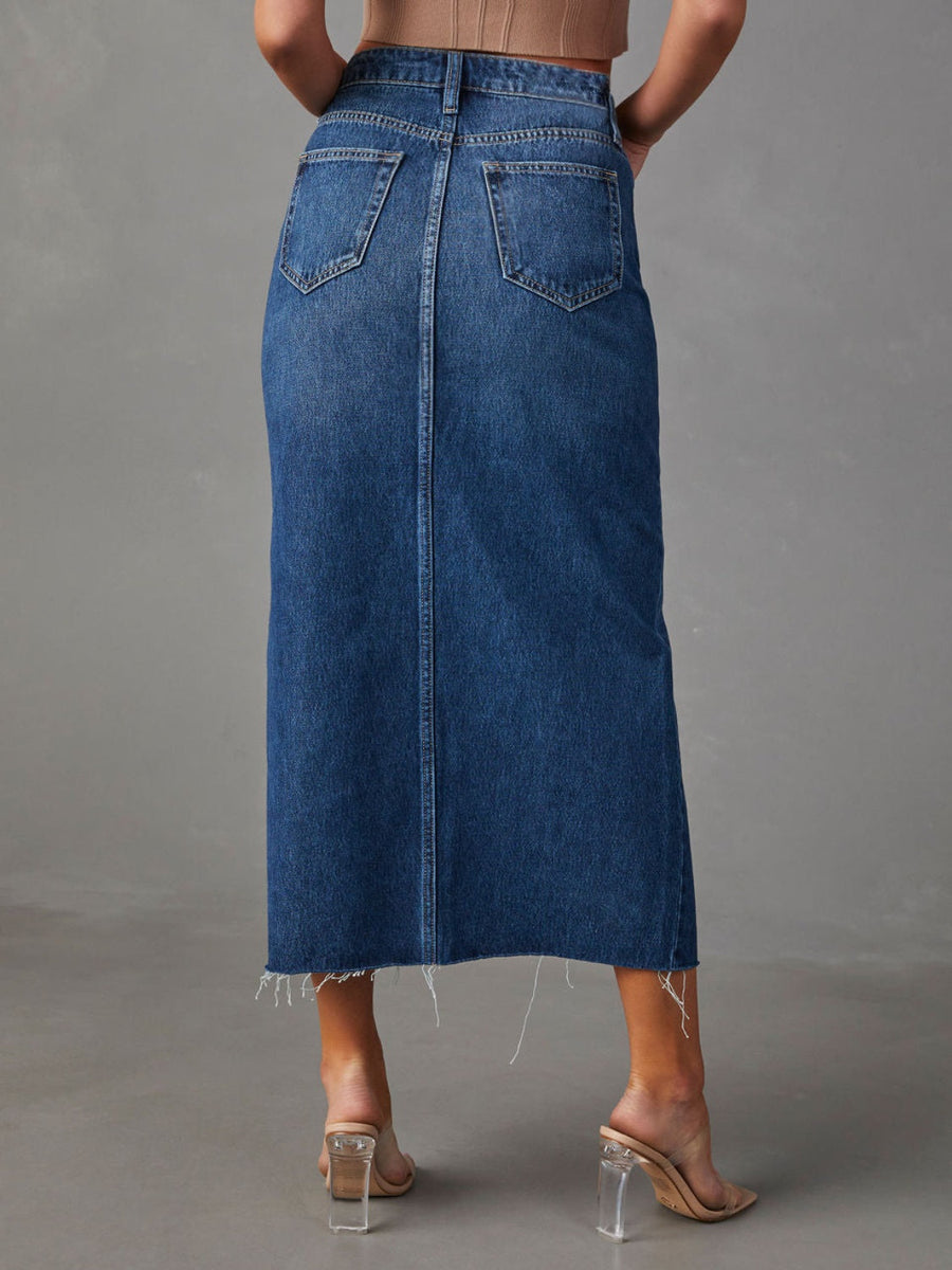 Slit-front denim midi skirt in dark blue with raw hem and buttoned closure.