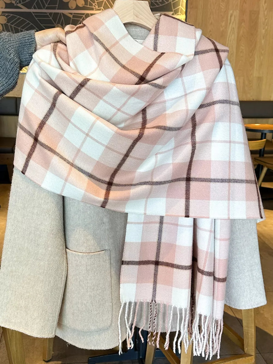 Plaid fringe scarf in pink and white with brown accents, draped over a neutral coat.