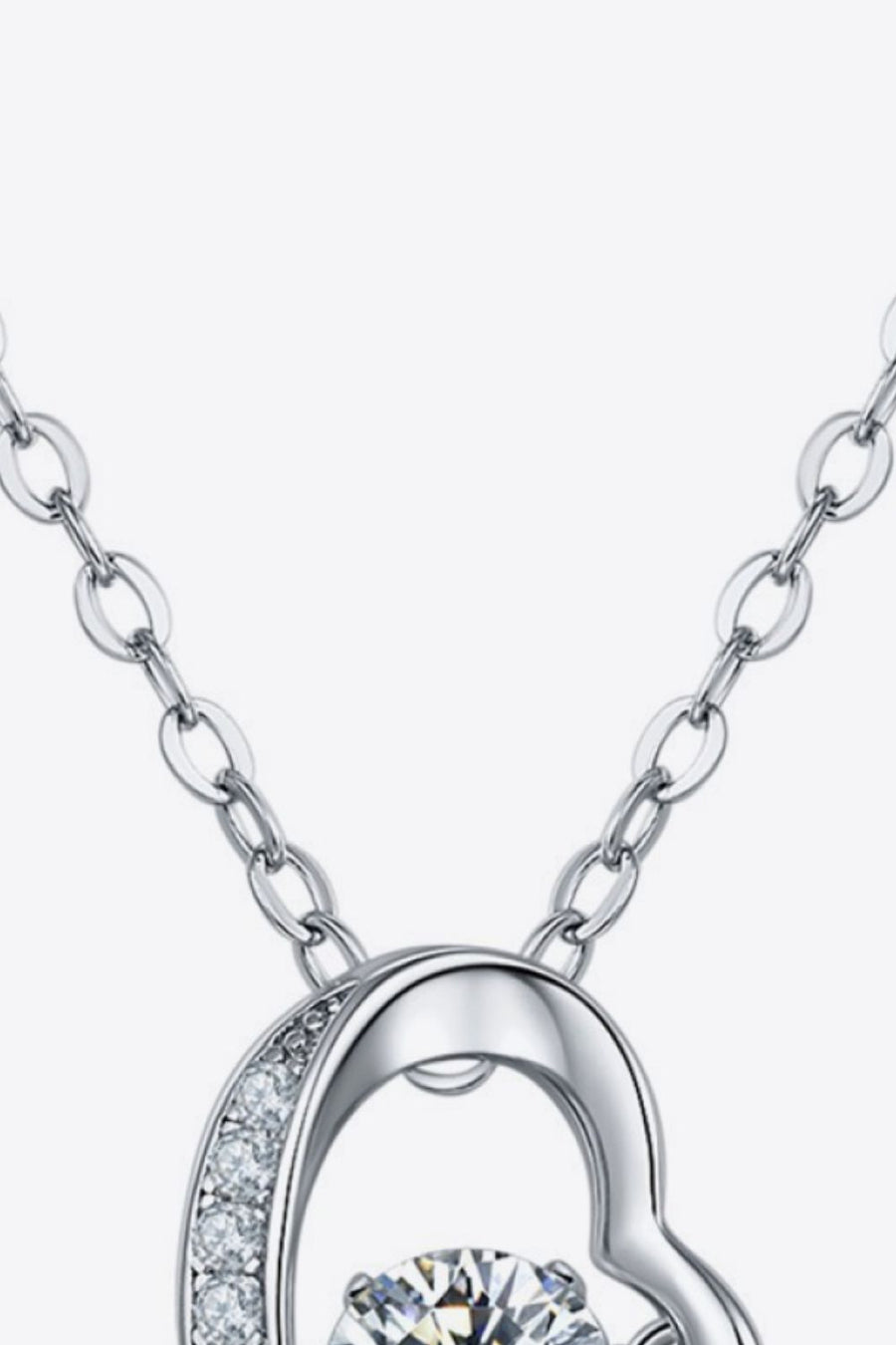 Silver necklace with a heart pendant featuring diamonds and a central stone.