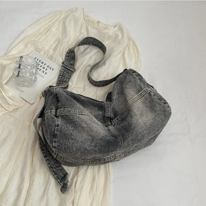 Washed denim hobo bag in medium grey with adjustable strap and slouchy silhouette.