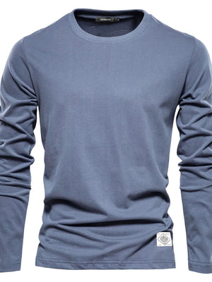 Dusty blue crew-neck long sleeve tee with textured fabric and a white patch detail.