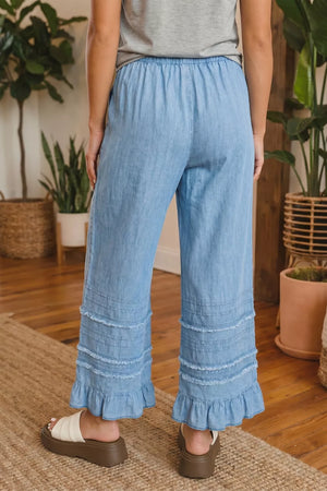 Light blue denim wide leg cropped pants with tiered ruffle hem and frayed detailing.