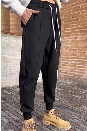 Men's black cotton sweatpants with white drawstring and cuffed ankles.