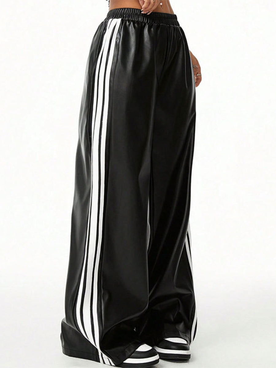 Black faux leather wide leg track pants with white side stripes and elastic waistband.