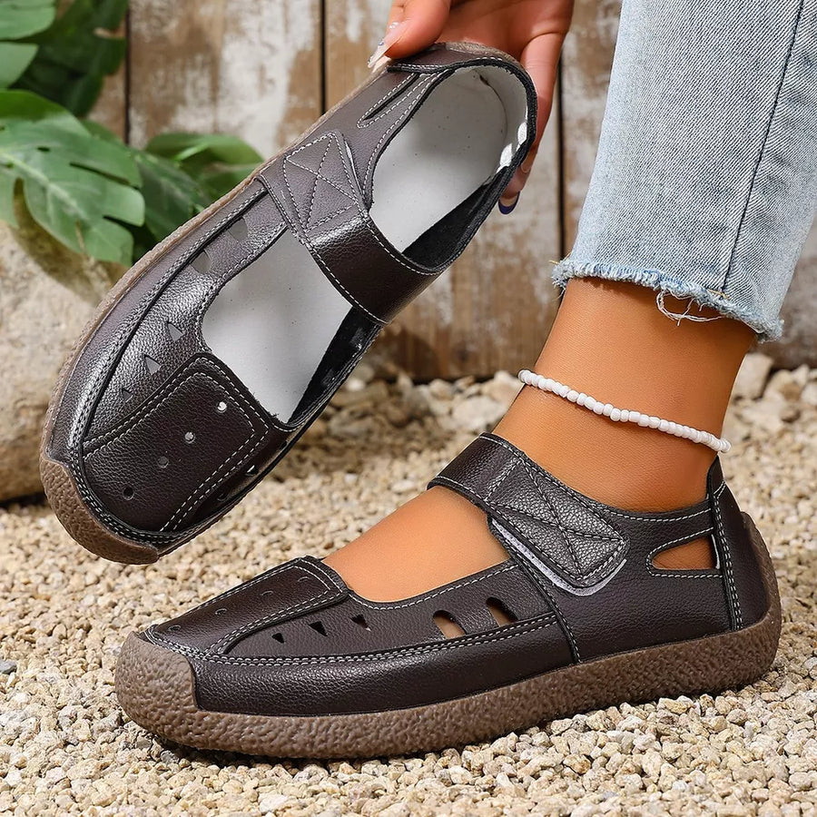 Brown leather round toe platform flats with cutouts and adjustable strap.