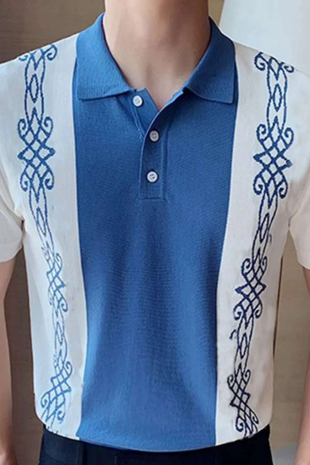 Embroidered panel polo shirt in dusty blue and white with ornate blue embroidery.