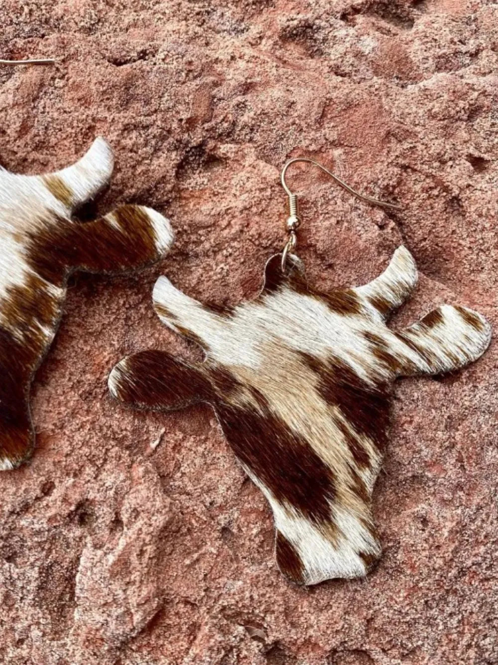 Cowhide silhouette drop earrings in brown and white, featuring a bull head design.