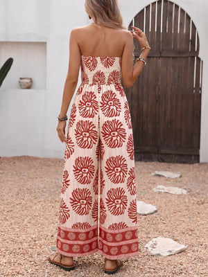 Strapless wide-leg romper with red floral print and smocked bodice.
