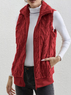 Red faux fur zip-up vest with textured pattern and ribbed hem.