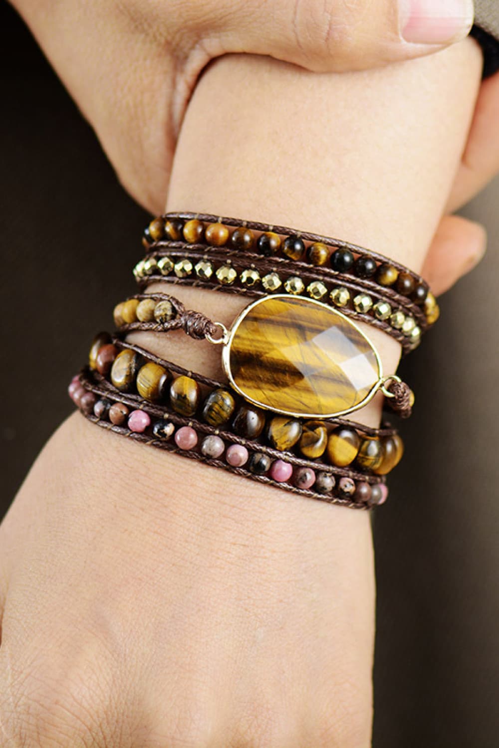 Wrap bracelet stack with tiger eye beads, pink stones, gold accents, and teardrop pendant on brown cord