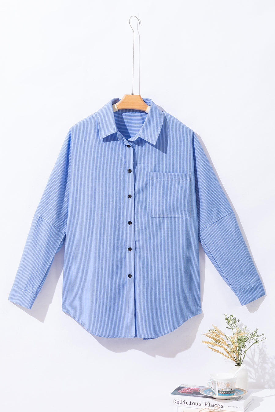 Light blue relaxed fit button-down shirt with vertical stripe texture and chest pocket.
