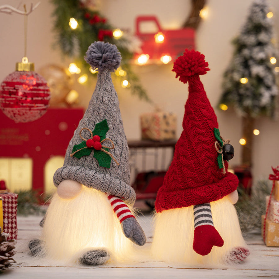 Illuminated knit gnomes, one gray with holly, one red with a bell, battery operated Christmas decor.